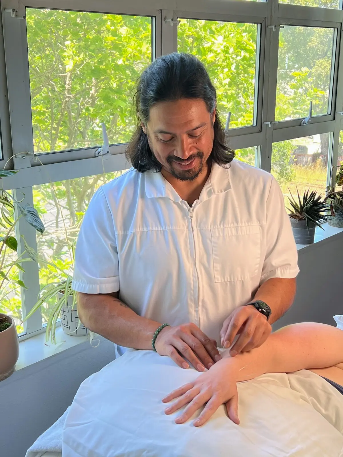 Dr. Daniel Rola, DTCM, LAC providing acupuncture treatment